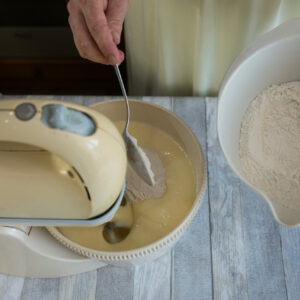 Cake making process. Female hands add flour to the mixer bowl for making dough. Step by step recipe for chocolate cake. Series. Baking concept.